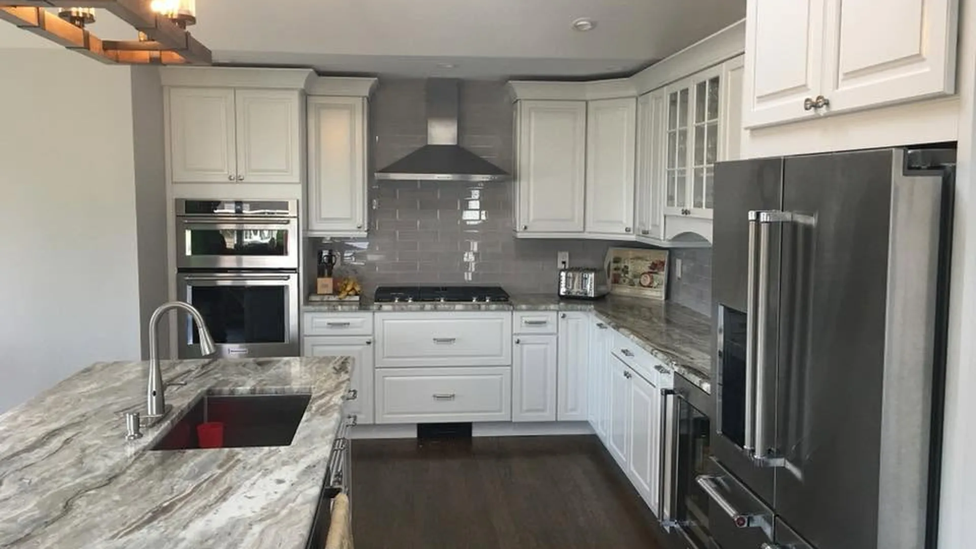 Kitchen remodel by North South Construction — white cabinets, subway tile and stone counters