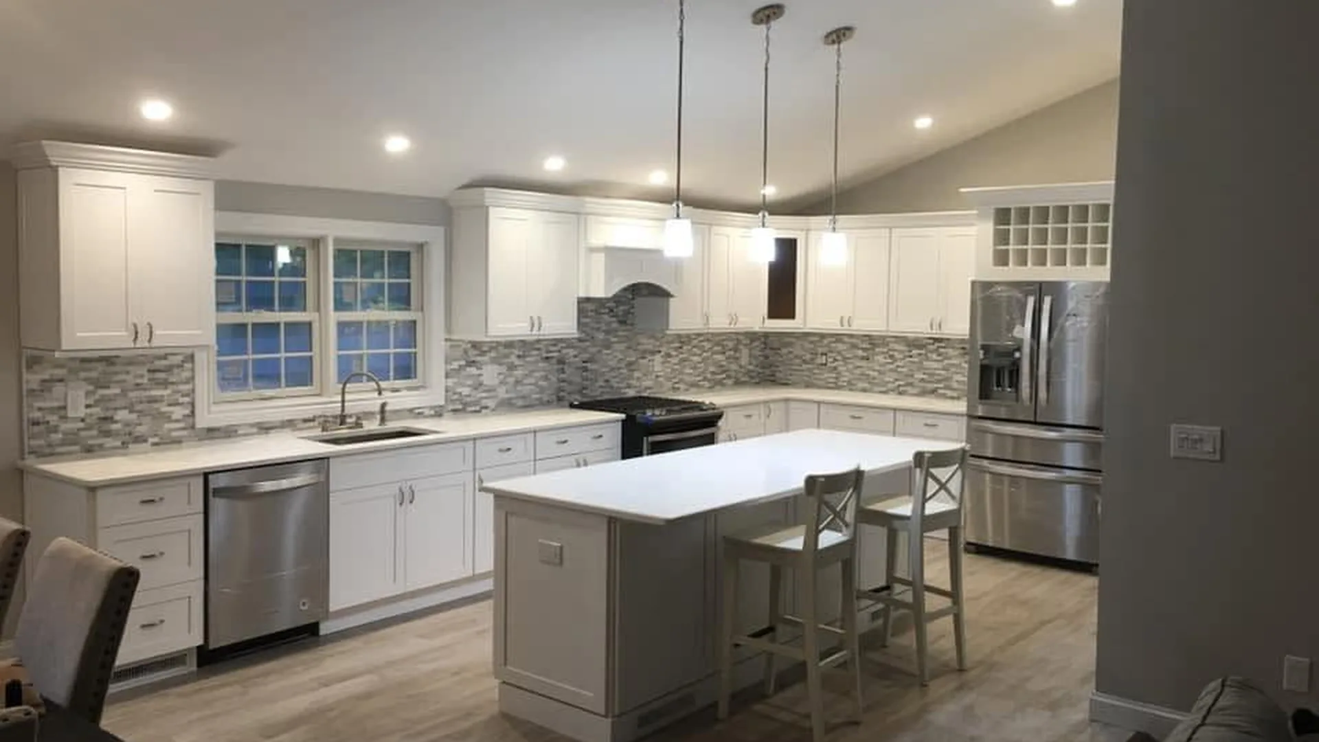 White shaker kitchen remodel by North South Construction with mosaic tile backsplash