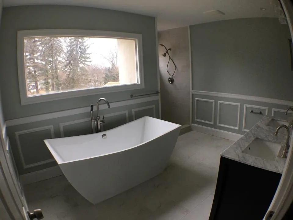 Bathroom remodel with freestanding soaking tub and marble vanity by North South Construction