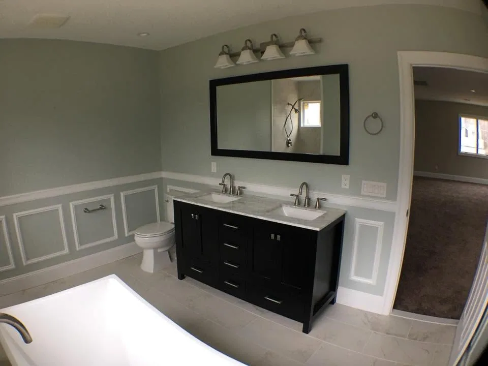 Primary bathroom remodel with double vanity and wainscoting by North South Construction