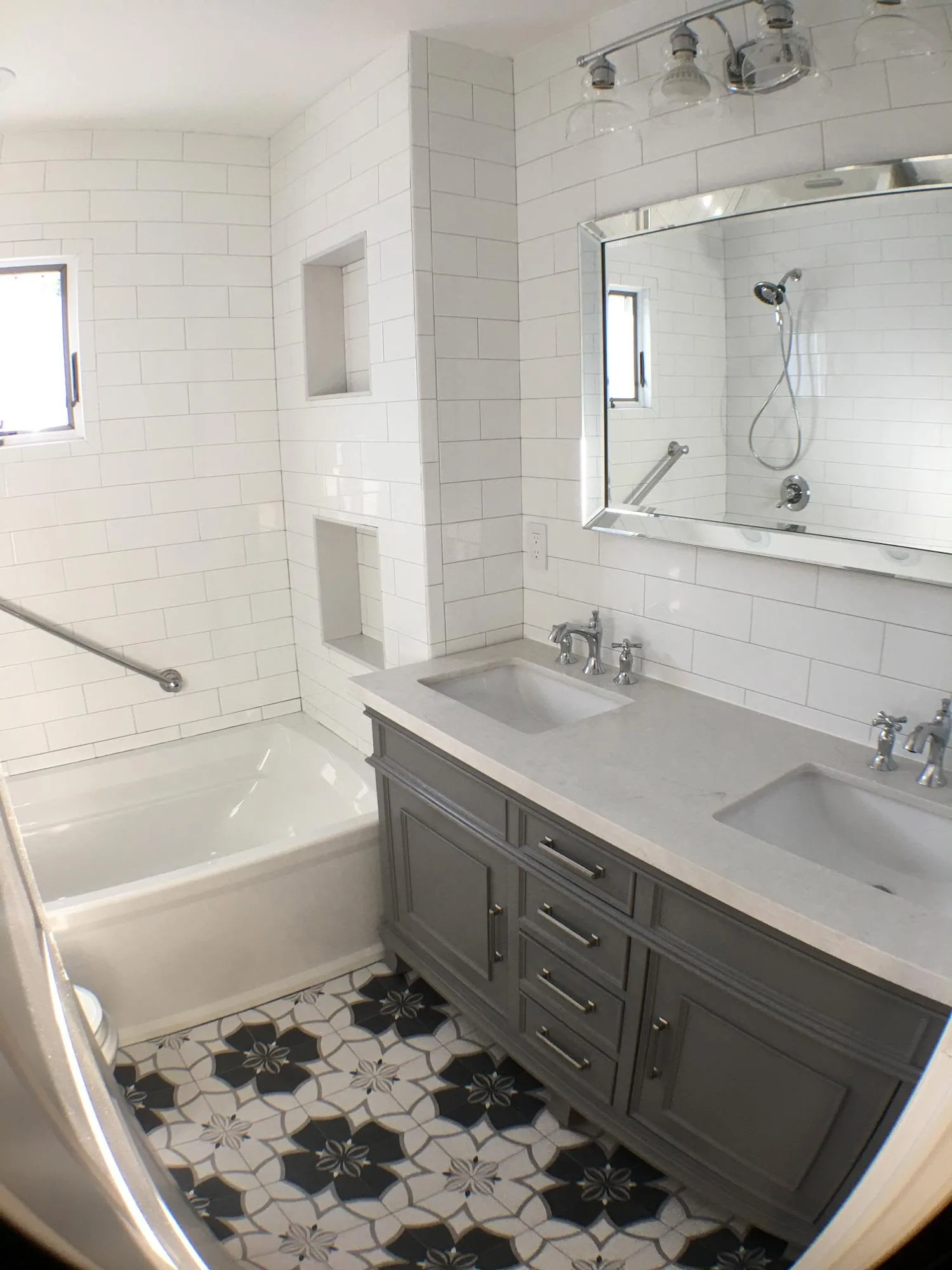 Bathroom remodel with subway tile and patterned floor by North South Construction