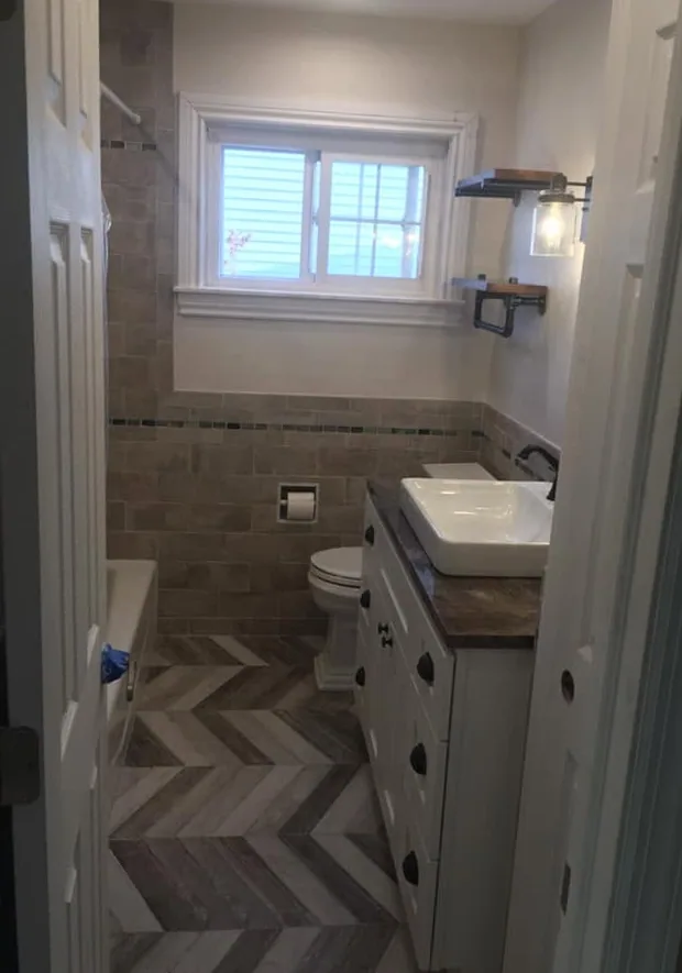 Bathroom remodel with chevron tile floor by North South Construction