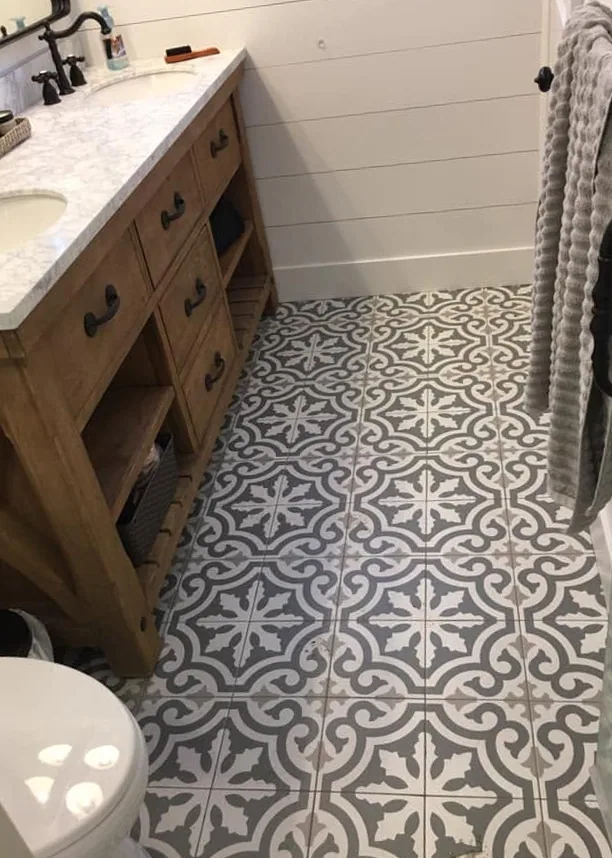 Bathroom remodel with patterned tile and wood vanity by North South Construction