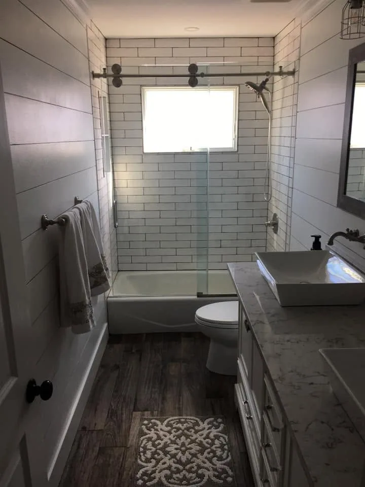 Bathroom remodel with shiplap walls and glass shower by North South Construction
