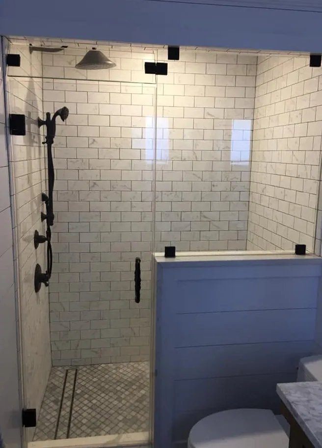 Custom walk-in tile shower with glass enclosure by North South Construction