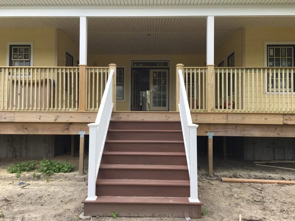 Wraparound porch with composite stairs by North South Construction
