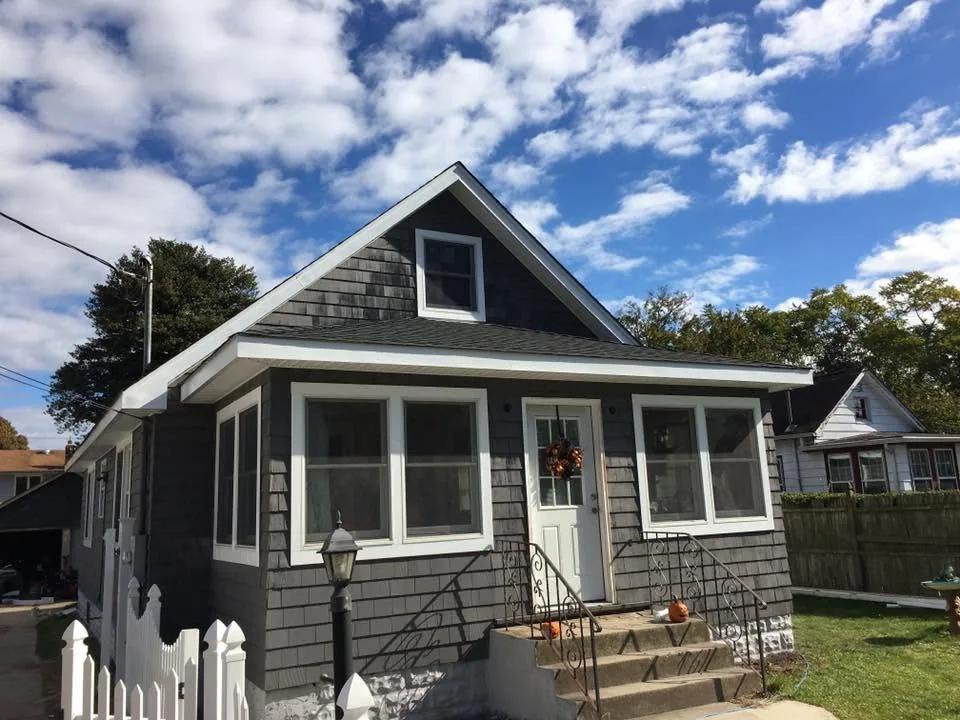 Exterior renovation with new shingle siding and white trim by North South Construction
