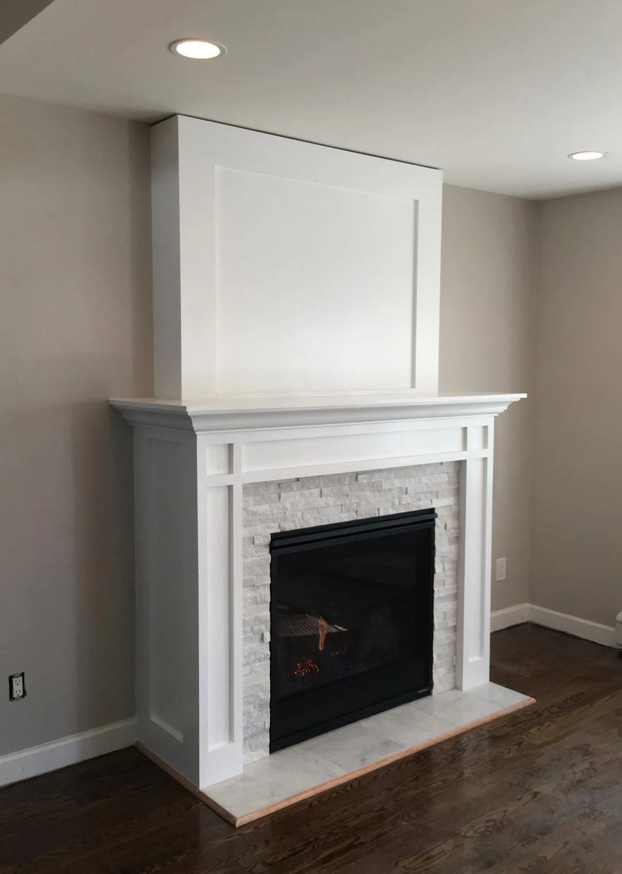 Living room renovation with stacked-stone fireplace by North South Construction