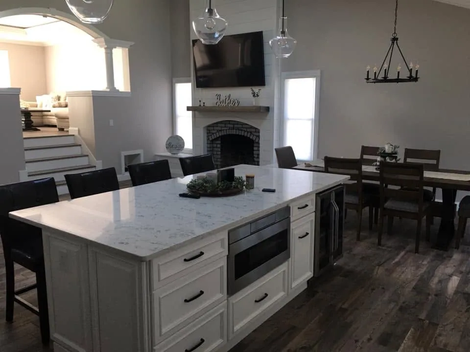 Open-plan kitchen island with marble countertop by North South Construction