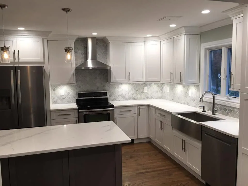 White shaker kitchen remodel with arabesque backsplash and farmhouse sink by North South Construction